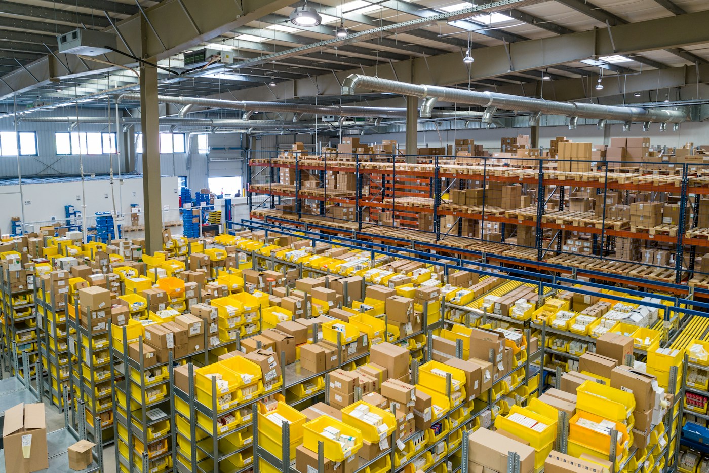 Real warehouse with inventory racks, parcels and sorting conveyors