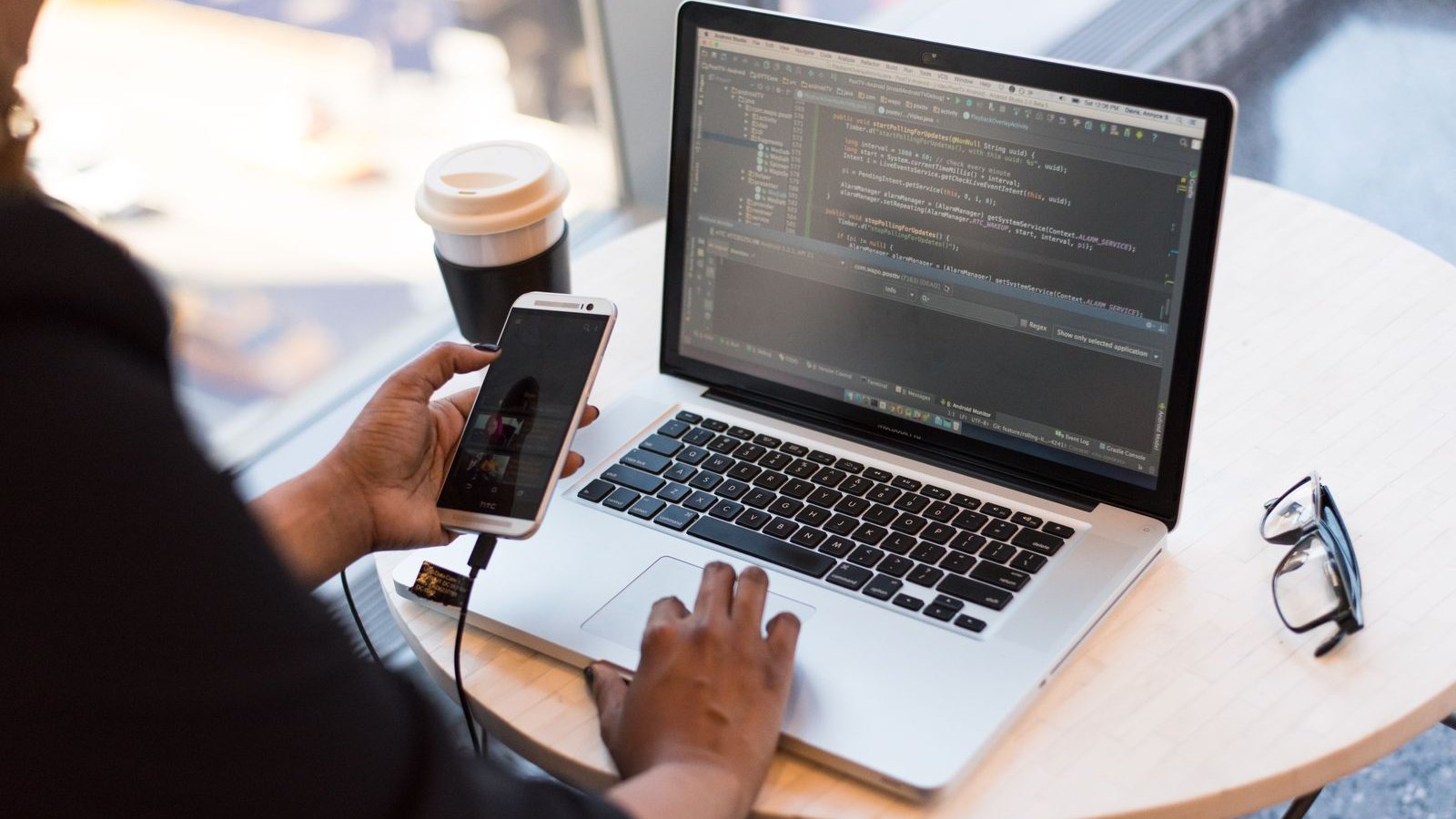 Tester checking a service on a mobile device and laptop