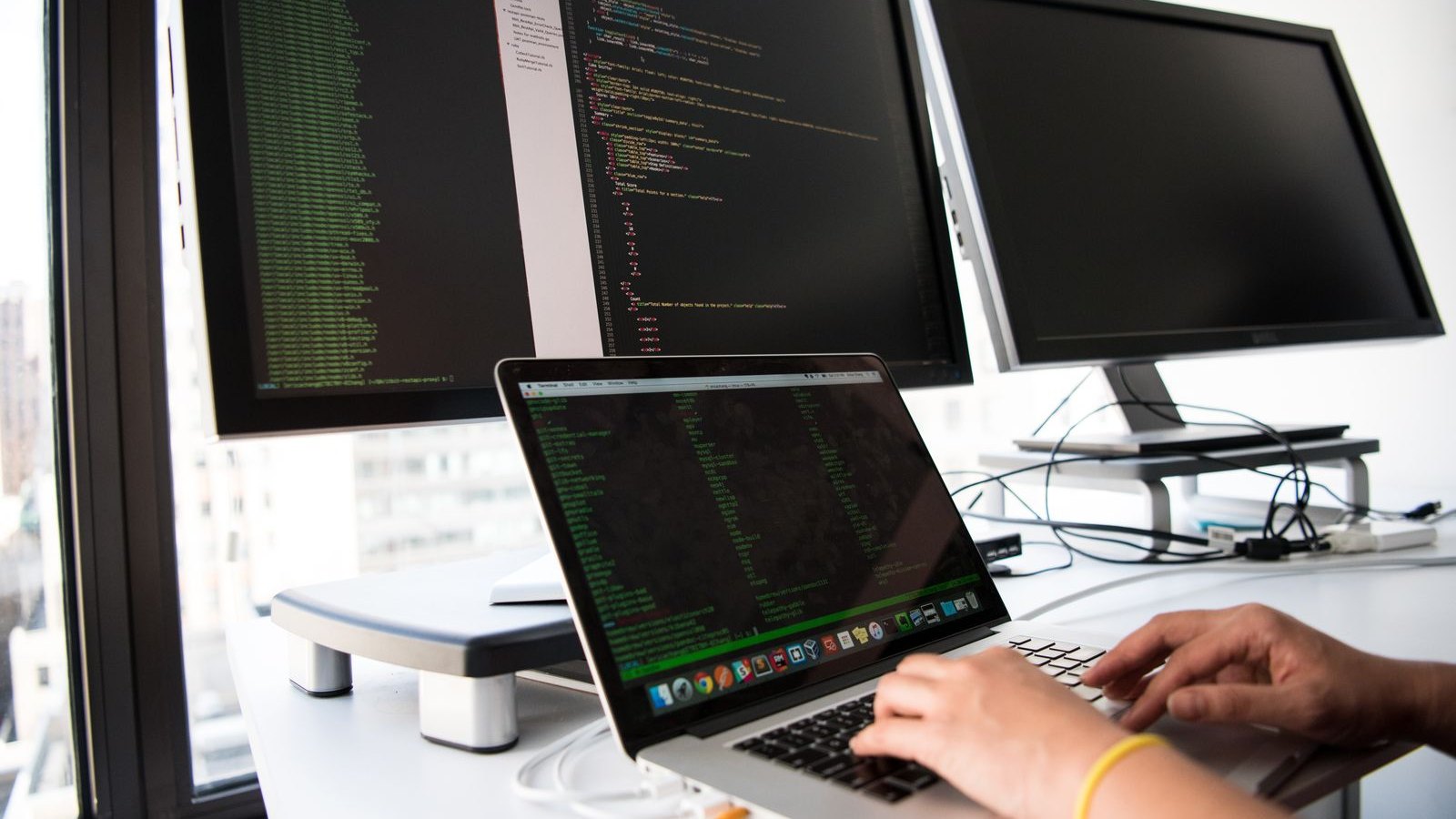 Developer inspecting API responses across multiple monitors